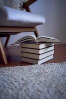 an ideal place for reading and relaxing, a white armchair surrounded by books in a bright room photo