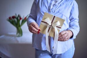 a medium-sized woman holds a craft gift certificate in her hands photo