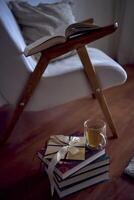 Gift certificate next to  perfect  place for reading and relaxing, a white armchair surrounded by books in a bright room photo