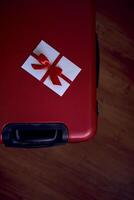 a gift certificate in red and white colors on a red suitcase for travel photo