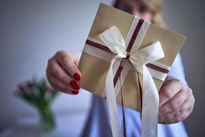 a medium-sized woman holds a craft gift certificate in her hands photo