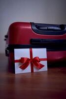 a gift certificate in red and white colors on a red suitcase for travel photo