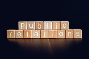 Wooden blocks form the text Public relations against a black background. photo