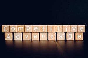 Wooden blocks form the text Competitive adventage against a black background. photo