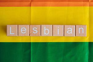 Wooden blocks form the text Lesbian against a rainbow background. photo