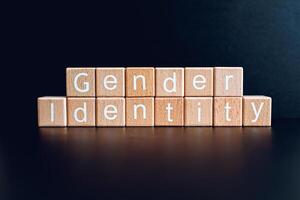 Wooden blocks form the text Gender Identity against a black background. photo