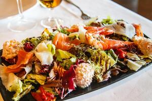 Salad with fish and seafood in the restaurant. photo