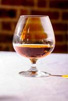 el destello desde el vaso de francés brandy reflejado en blanco lengüeta foto