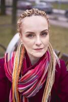 retrato de un elegante de edad mediana mujer con trenzas en un primavera calle foto