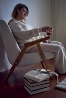 un talla media mujer se sienta en un Sillón leyendo un libro y Bebiendo whisky, un regalo certificado es siguiente a su foto