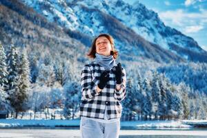 niña jugar por el lago en frente de montañas foto