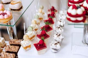 Candy bar at a wedding. Delicious desserts. Beautiful decorations. Fruits. Sweet cakes on your holiday. Birthday. Sweet life. photo