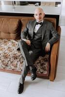 Portrait of a young groom at home before the wedding ceremony. A handsome man dressed in a classic suit. Male portrait. photo