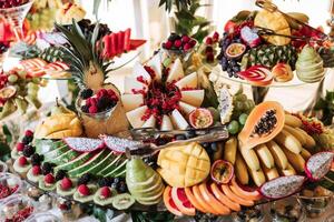 Fruit buffet for a wedding. Assortment of exotic fruits in the restaurant. Various compositions from fresh fruits. photo