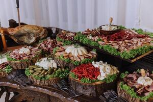 Meat and cheese snacks on the buffet. A buffet in a closed room, at a wedding celebration or birthday. Sandwiches on skewers before the start of the holiday. photo