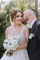 The bride is dressed in an elegant lush white wedding dress with a long veil and is ready for her groom. The first meeting of the bride and groom photo