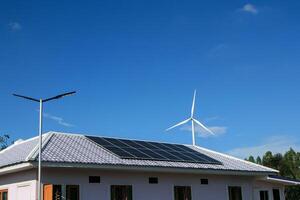 Newly installed solar panels on roofs of houses without access to electricity. Available both indoors and illuminated walkways. There are also wind turbines surrounding the area as well. photo