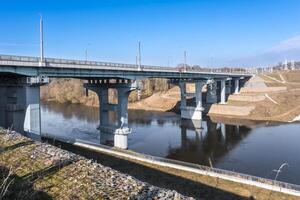 acero marco y hormigón construcción enorme coche puente a través de el amplio río foto