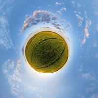 simple green tiny planet without buildings in blue sky with beautiful clouds. Transformation of spherical panorama 360 degrees. Spherical abstract aerial view. Curvature of space. photo