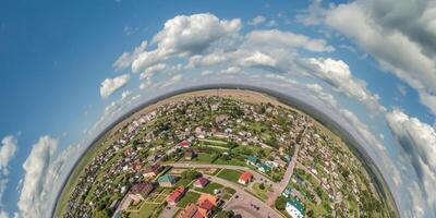 Aerial view from high altitude tiny planet in sky with clouds overlooking old town, urban development, buildings and crossroads. Transformation of spherical 360 panorama in abstract aerial view. photo