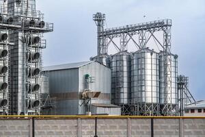 agro-industrial complex with silos and a seed cleaning and drying line for grain storage  in snow of winter field photo