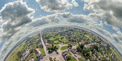 Aerial view from high altitude tiny planet in sky with clouds overlooking old town, urban development, buildings and crossroads. Transformation of spherical 360 panorama in abstract aerial view. photo