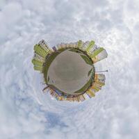 tiny planet in blue sky with clouds in city center near modern skyscrapers. Transformation of spherical 360 panorama in abstract aerial view. photo