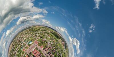 aéreo ver desde alto altitud minúsculo planeta en cielo con nubes con vista a antiguo ciudad, urbano desarrollo, edificios y cruce. transformación de esférico 360 panorama en resumen aéreo vista. foto