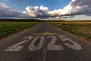 números 2025 Vamos y comienzo en asfalto la carretera autopista con amanecer o puesta de sol cielo antecedentes. concepto de destino en futuro, libertad, trabajo comenzar, correr, planificación, desafío, objetivo, nuevo año foto