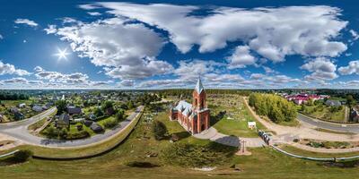 aerial full hdri 360 panorama  view on red brick neo gothic catholic church near cemetery in countryside or village in equirectangular projection with zenith and nadir. VR  AR content photo