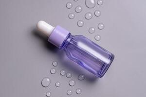 Transparent violet cosmetic bottle with pipette on grey background with water drops, product packaging, anti aging serum with peptides, hyaluronic cosmetics mockup, spa concept photo