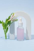 Cosmetic bottle with body and face oil with alstromeria flower in the arch, summer natural cosmetics, serum, facial oil, tropical concept photo