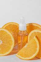 Citrus essential oil, vitamin c serum with fresh juicy orange fruit on white background. Organic Spa Cosmetic With Herbal Ingredients. Toning. High dose vitamin c synthetic for skin photo