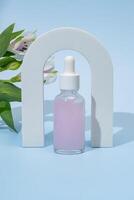 belleza colágeno cara suero en un vaso cuentagotas botella arco en azul antecedentes con alstromeria flor. de moda disparar de productos cosméticos embalaje esencial petróleo con natural ingredientes Copiar espacio foto