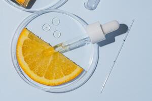 Petri dishes with orange research. Cut orange, research in the laboratory. Bioengineering, laboratory. AHA acids , cosmetics production photo