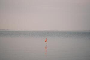 Calm water and red flag photo