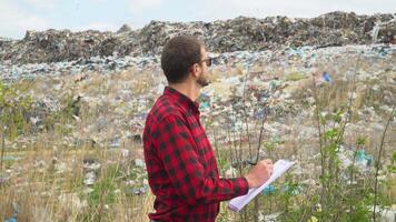 Garbage dump inspector records pollution level. Ecology pollution concept video