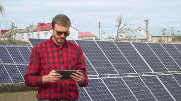 Successful young engineer with tablet planning futuristic solar panels power plant video