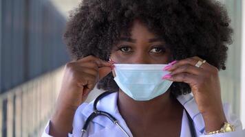 vicino su di africano americano medico nel protettivo maschera. covid-19 protezione video