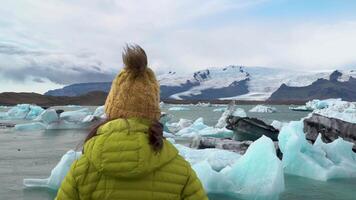 island resa turist njuter se av natur landskap jokulsarlon glacial- lagun. flicka utomhus förbi turist destination landmärke attraktion. Vatnajokull nationell parkera, island. 4k video