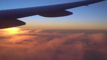 Aussicht von das Flugzeug Fenster von das Flügel, Wolken und ein schön Sonnenuntergang. video