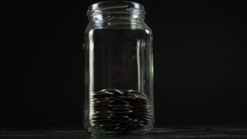 Time lapse of money coin in glass bottle growing growth saving money. Concept financial business investment. Black background. 4K video