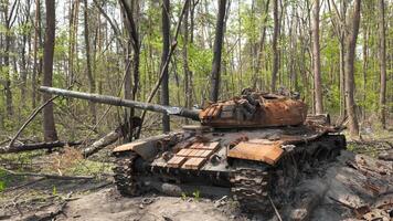 förstörd och bränt ut tank av de ryska armén som en resultat av de slåss med ukrainska trupper i de skog nära Kiev, ukraina. ryska aggression i ukraina. video