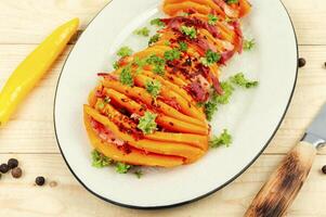 Baked pumpkin or squash with bacon. photo