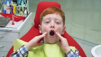 Scared boy at reception at dentist in dental chair. Pediatric dentistry video