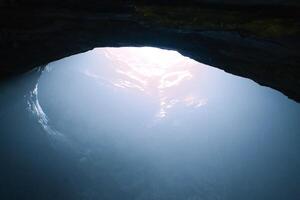 Rock cave with hole through which light shines. Underworlds in Sweden. Mystical photo