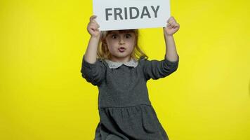 Child girl showing Black Friday inscription, smiling, looking satisfied with low prices, discounts video