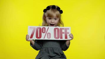 Child girl showing Up To 70 percent Off inscription, rejoicing discounts for online shopping sales video