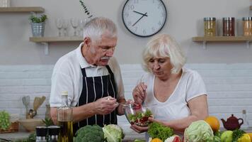 Senior mulher e homem alimentando cada de outros com fresco cru vegetal salada. eco Comida comendo dieta video