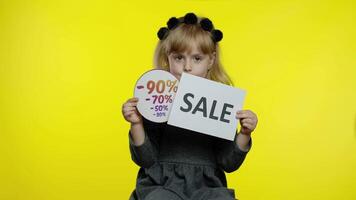 bambino ragazza mostrando vendita parola e sconti annuncio pubblicitario iscrizioni striscioni. nero Venerdì concetto video